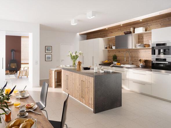 Impressionen einer Küche mit Esszimmer mit hellen Holzmöbeln und dunklen und weißen Fronten im Kontrast